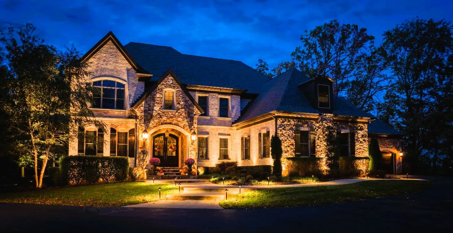 Grenata Stone Front home with landscape lighting. Professional landscape lighting