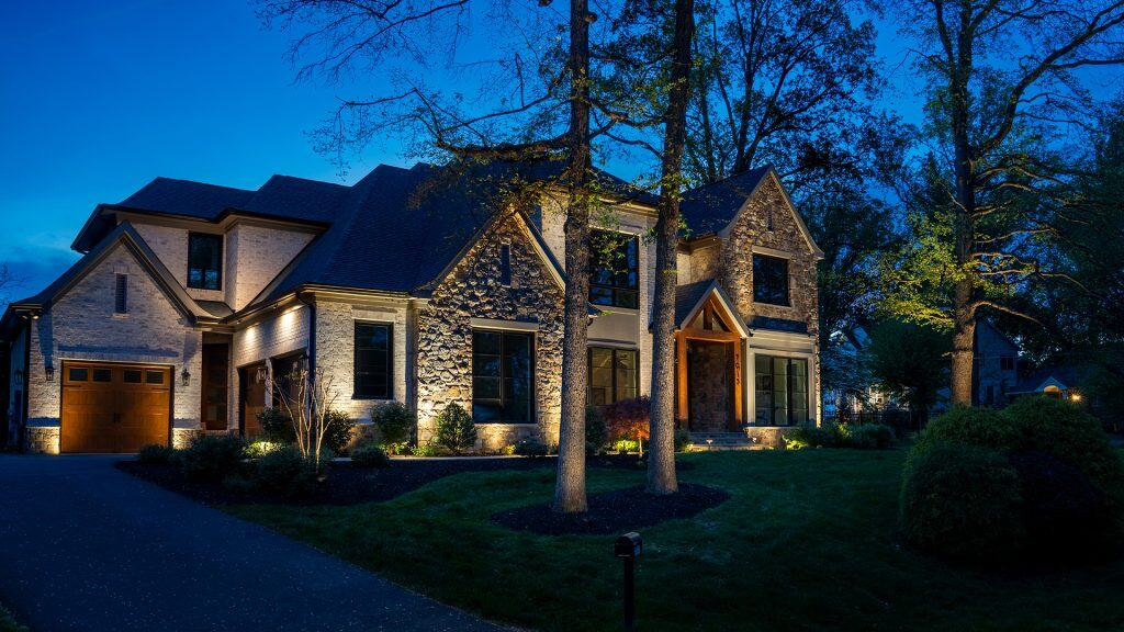 Landscape lighting in McLean VA highlighting a residence with illuminated porch and front exterior.